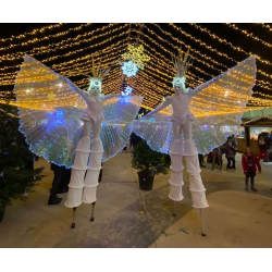 Personajes con Alas Iluminadas en Zancos