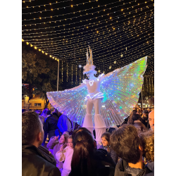 Personajes con Alas Iluminadas en Zancos